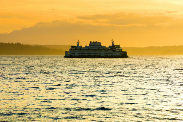 istock Ferry boat sailing across water at sunset 1354148459