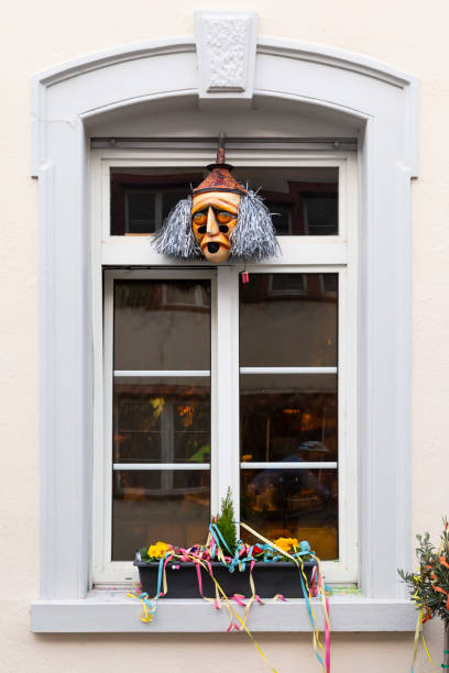 Basel, Switzerland - February 21. Carnival window decoration with a mask and colorful garlands