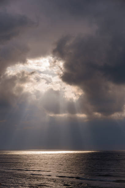 istock The sun's rays passing through the storm clouds over the sea 1354153485