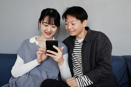 Asian couple watching photos on phone
