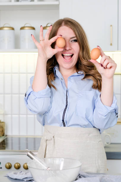 istock Young beautiful woman prepares in a bright kitchen 1354154653