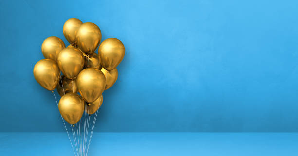 istock Gold balloons bunch on a blue wall background. Horizontal banner. 1354155128