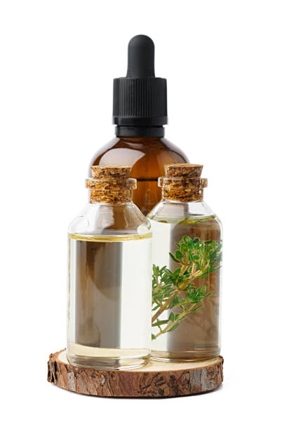 istock Essential oil in a small bottle with green leaf on white background 1354155359
