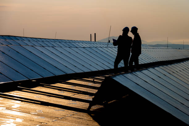 istock Male engineers discussing while standing on the rooftop of solar plant 1354157172
