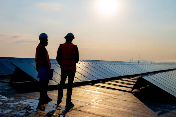 istock Male engineers discussing while standing on the rooftop of solar plant 1354157196
