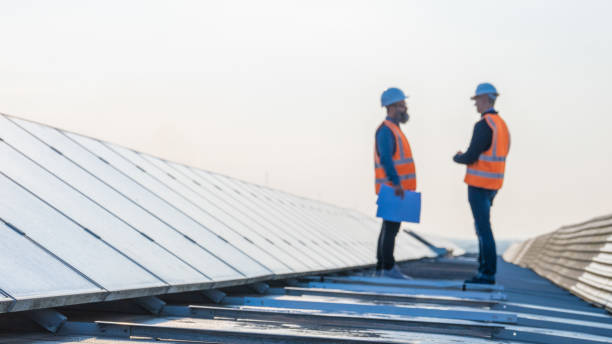 istock Male engineers discussing while standing on the rooftop of solar plant 1354157271