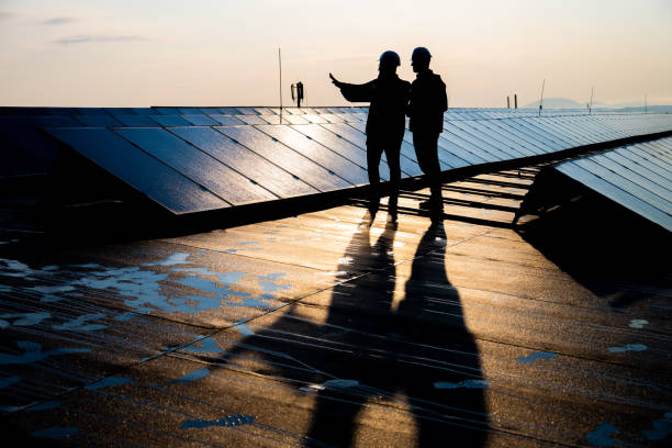 istock Male engineers discussing while standing on the rooftop of solar plant 1354157287