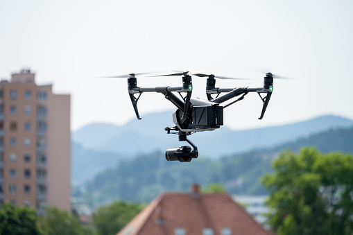 View of drone with camera flying over city.