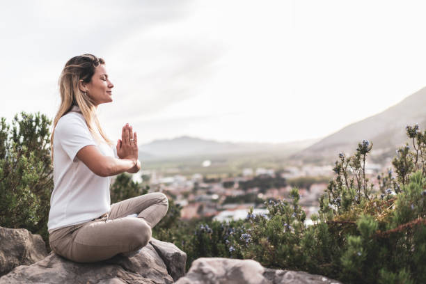 istock Young woman preforms yoga in mountains at sunset 1354157583