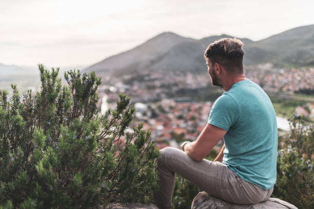istock Young man enjoying mountains at sunset 1354157726