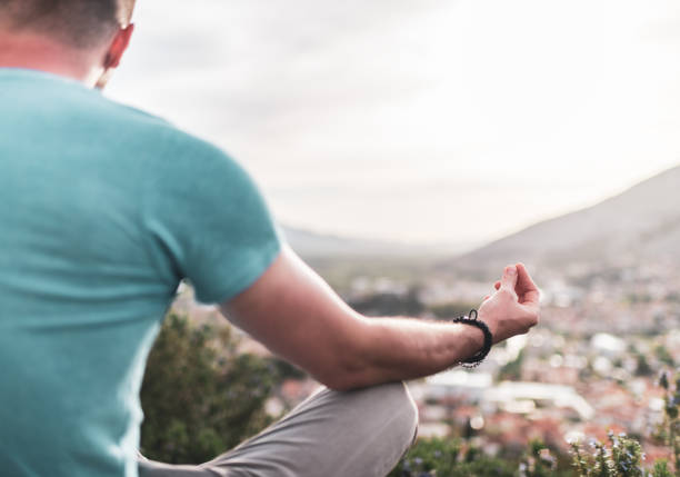 istock Young man preforms yoga in mountains at sunset 1354157764