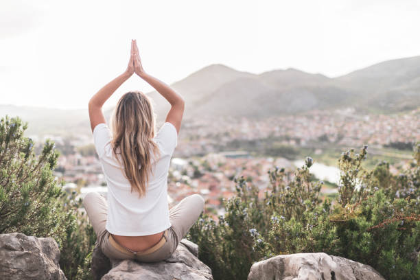 istock Young woman preforms yoga in mountains at sunset 1354157782