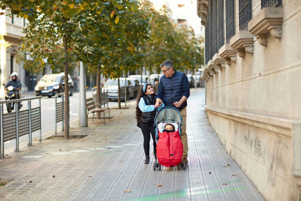 istock Father Pushing Stroller and Walking with Daughter 1354158688