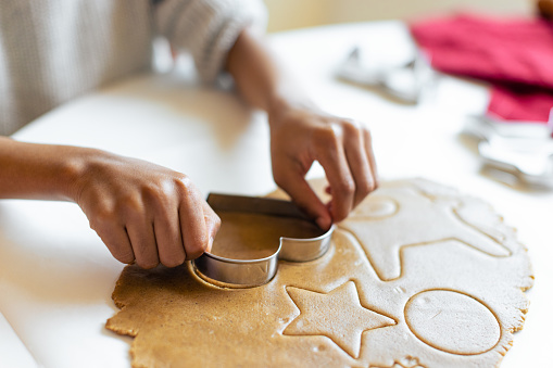 Close up of a female child hands making gingerbread cookies. Using shape mold