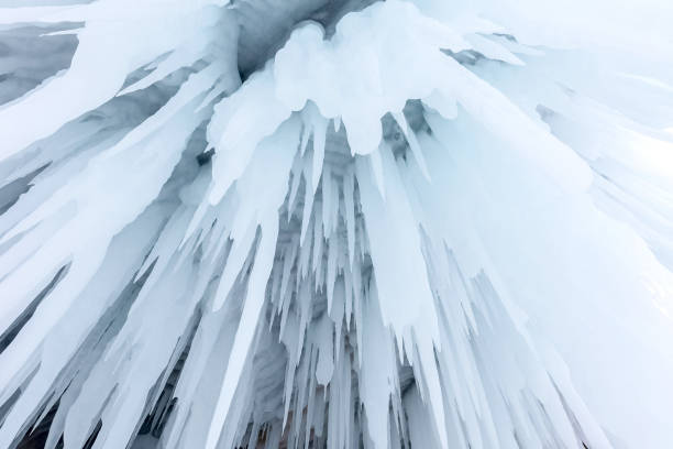 Icy natural pattern. Huge ice stalactites in an ice cave. Lake Baikal.
