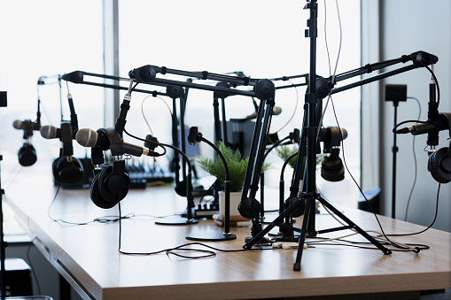 A photo of the array of microphones and headphones in the empty podcast studio.  The studio is for rent.
