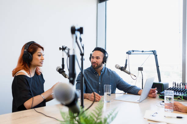istock Podcasters use equipment in rental studio to record show 1354169910