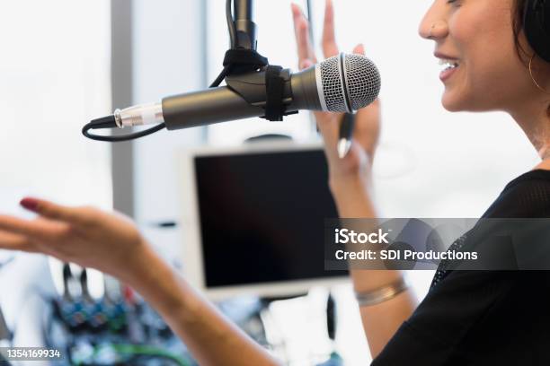 Mid Adult Woman Gestures While Recording Podcast In Studio Stock Photo - Download Image Now