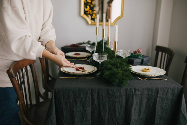 istock Young woman serving Christmas table with beautiful festive tableware. Preparations for holiday dinner. 1354171152