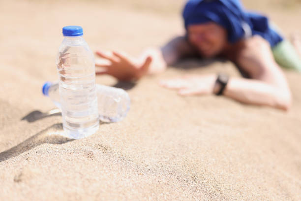 사막에서 모래에 누워 갈증을 느끼는 남자 - thirsty desert men reaching 뉴스 사진 이미지