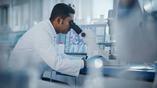 istock Medical Research Laboratory: Male Scientist Looking Under Micrsocope, Analyzing Samples. Advanced Scientific Lab Biotechnology, Medicine, Microbiology, Drugs Development. 1354172478