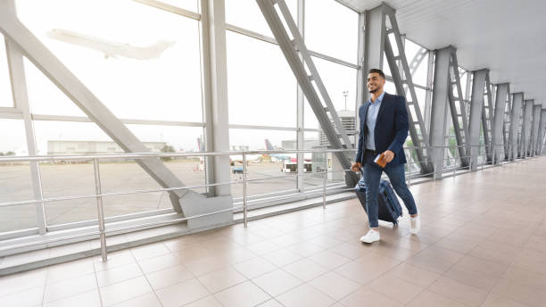 istock Ready For Journey. Smiling Handsome Middle-Eastern Man Walking With Suitcase In Airport 1354172863