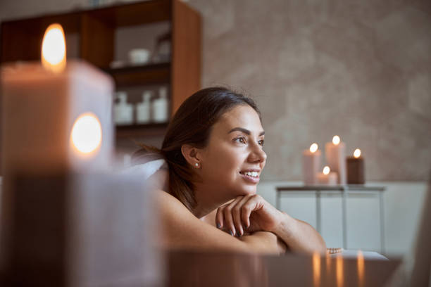 une jeune femme atractive dans un salon de massage subit des procédures de beauté et de soins de santé - massage therapist massaging sport beautician photos et images de collection