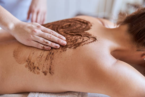 une jeune femme atractive dans un salon de massage subit des procédures de beauté et de soins de santé - massage therapist massaging sport beautician photos et images de collection