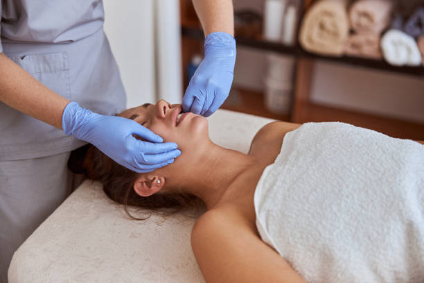 junge atraktive frau im massagesalon hat schönheits- und gesundheitsbehandlungen - massage table massaging sport spa treatment stock-fotos und bilder