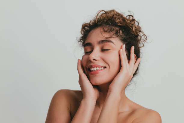 mujer joven sonriente con oído rizado y piel clara - cuidado del cuerpo fotografías e imágenes de stock