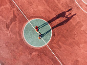 istock Two friends are playing basketball together, holding hands before the start - Aerial point of view 1354175028
