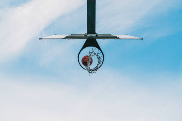 una pelota de baloncesto está entrando en el aro de baloncesto - moviendo hacia abajo fotografías e imágenes de stock