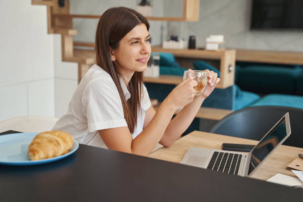 istock Caucasian female freelancer daydreaming at her laptop 1354175637
