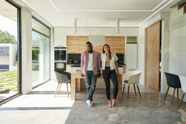 istock Joyous mixed-race couple posing for camera in kitchen 1354175693