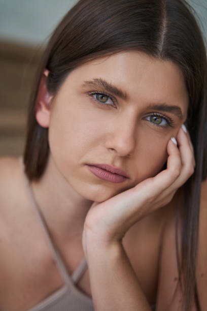 istock Despondent woman leaning her cheek on hand and staring ahead 1354175921