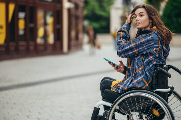 istock Woman with disability using a smartphone while out in the city 1354176281