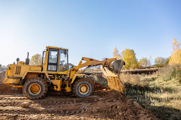 large yellow wheel loader aligns a piece of land for a new building. Preparation of the land for the auction. Leveling the landscape and adding sand for construction large yellow wheel loader aligns a piece of land for a new building. Preparation of the land for the auction. Leveling the landscape and adding sand for construction. Banner wallpaper. earthwork stock pictures, royalty-free photos & images