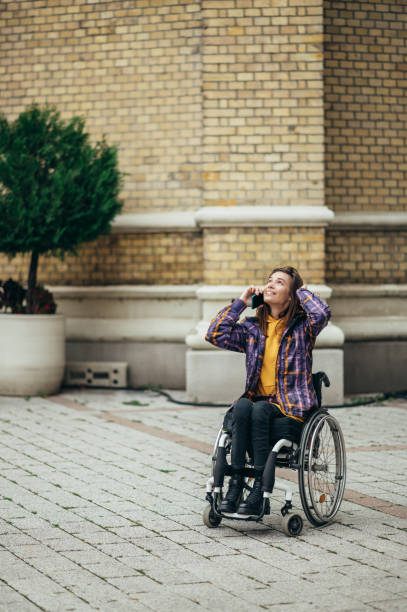istock Woman with disability using a smartphone while out in the city 1354176657
