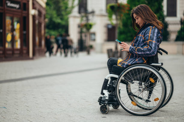 istock Woman with disability using a smartphone while out in the city 1354176659