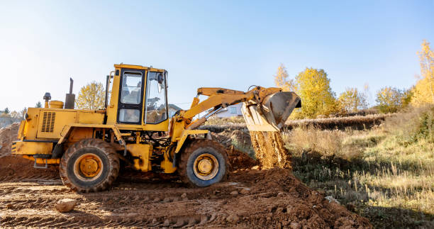 large yellow wheel loader aligns a piece of land for a new building. Preparation of the land for the auction. Leveling the landscape and adding sand for construction. large yellow wheel loader aligns a piece of land for a new building. Preparation of the land for the auction. Leveling the landscape and adding sand for construction. Banner wallpaper. Earthmoving stock pictures, royalty-free photos & images