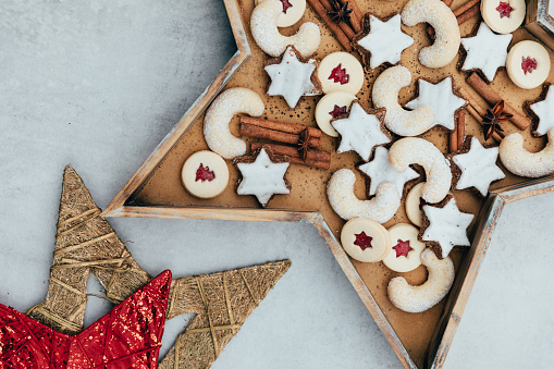 Swiss Christmas cookies arranged in a wooden star-shaped form on white background. Advent tradition in Switzerland to bake cookies.