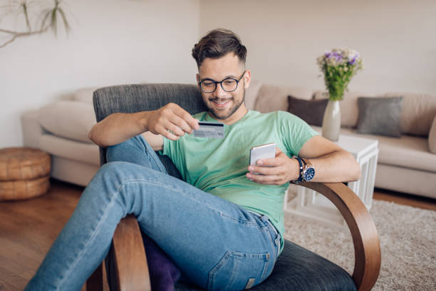 istock Happy young man banking  online at home 1354177742