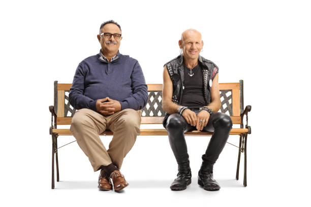 istock Mature man and a punk in leather clothes sitting on a bench 1354177825