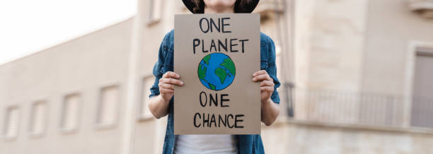 istock Young activist marching and protest for climate change holding banner - Demonstration for Ecology and environment concept 1354178238