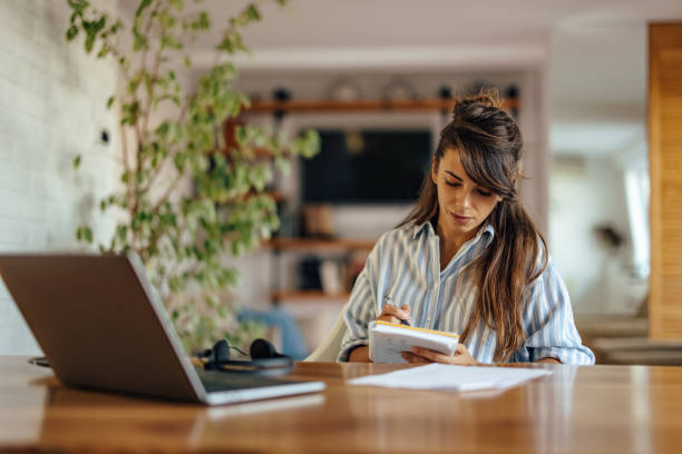 istock Serious caucasian woman, using her notepad during a call 1354178958