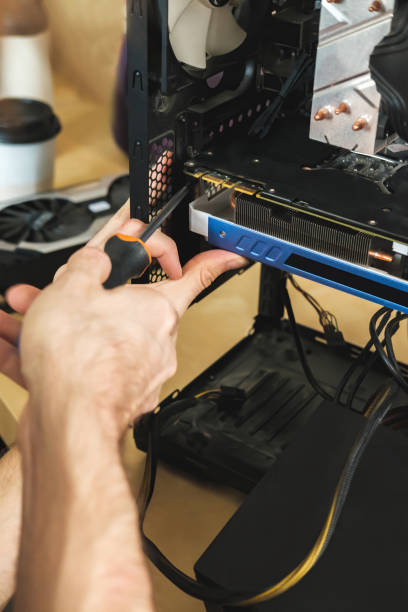 istock Young man repairs a computer system unit, changes parts, video card and hard drive, sets new components. Computer Repair Wizard. 1354179119