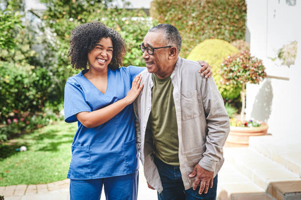 shot of an attractive young nurse bonding with her senior patient outside - ouderenzorg stockfoto's en -beelden