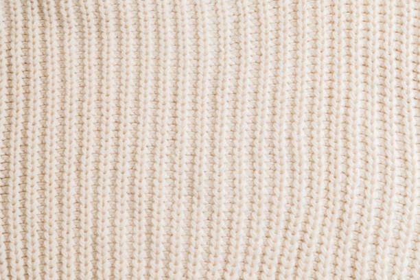 Woolen knitted patterned fabric with folds background texture textile. stock photo