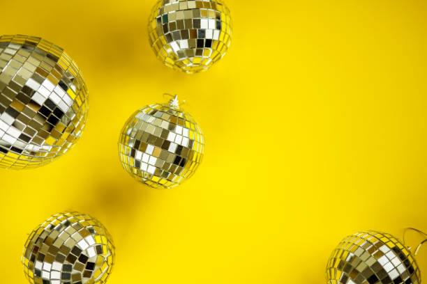 Disco mirror ball Christmas tree toy on a bright festive yellow background. Christmas and New Year holiday party concept. View from above. Flat lay. stock photo