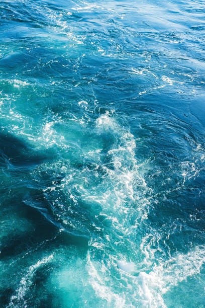 Sea or ocean waves surface texture. Abstract summer blue water background with splashes of sea foam. stock photo
